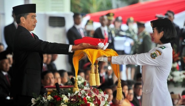 Maria Sedang Menerima Duplikat Bendera Kebangsaan dari Presiden Jokowi